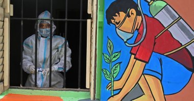 A health worker wearing a protective suit stands in the window of a newly inaugurated "Oxygen Hub" for COVID-19 patients in Kolkata, West Bengal, India, May 23, 2021. (AFP Photo)
