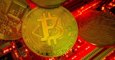 Representations of the virtual currency Bitcoin stand on a motherboard in this picture illustration taken May 20, 2021. (Reuters Photo)