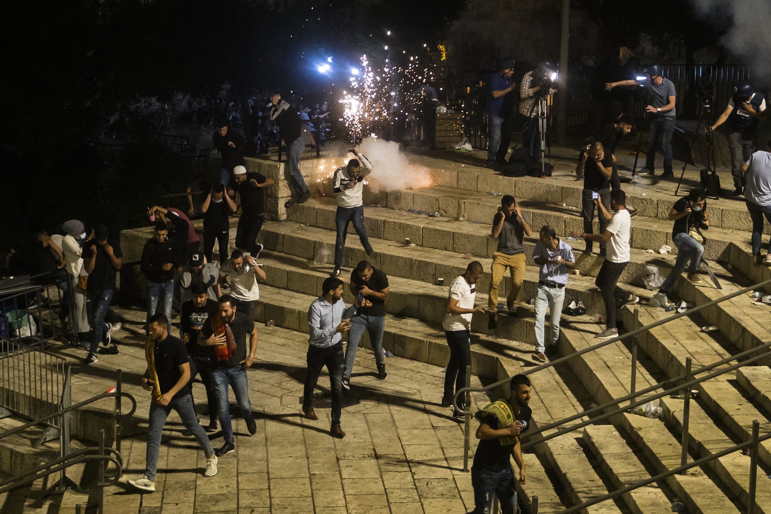 Palestinians escape from a stun grenade fired by Israeli forces at Damascus Gate during the holy month of Ramadan, in East Jerusalem, occupied Palestine, May 8, 2021. (Photo by Getty Images)