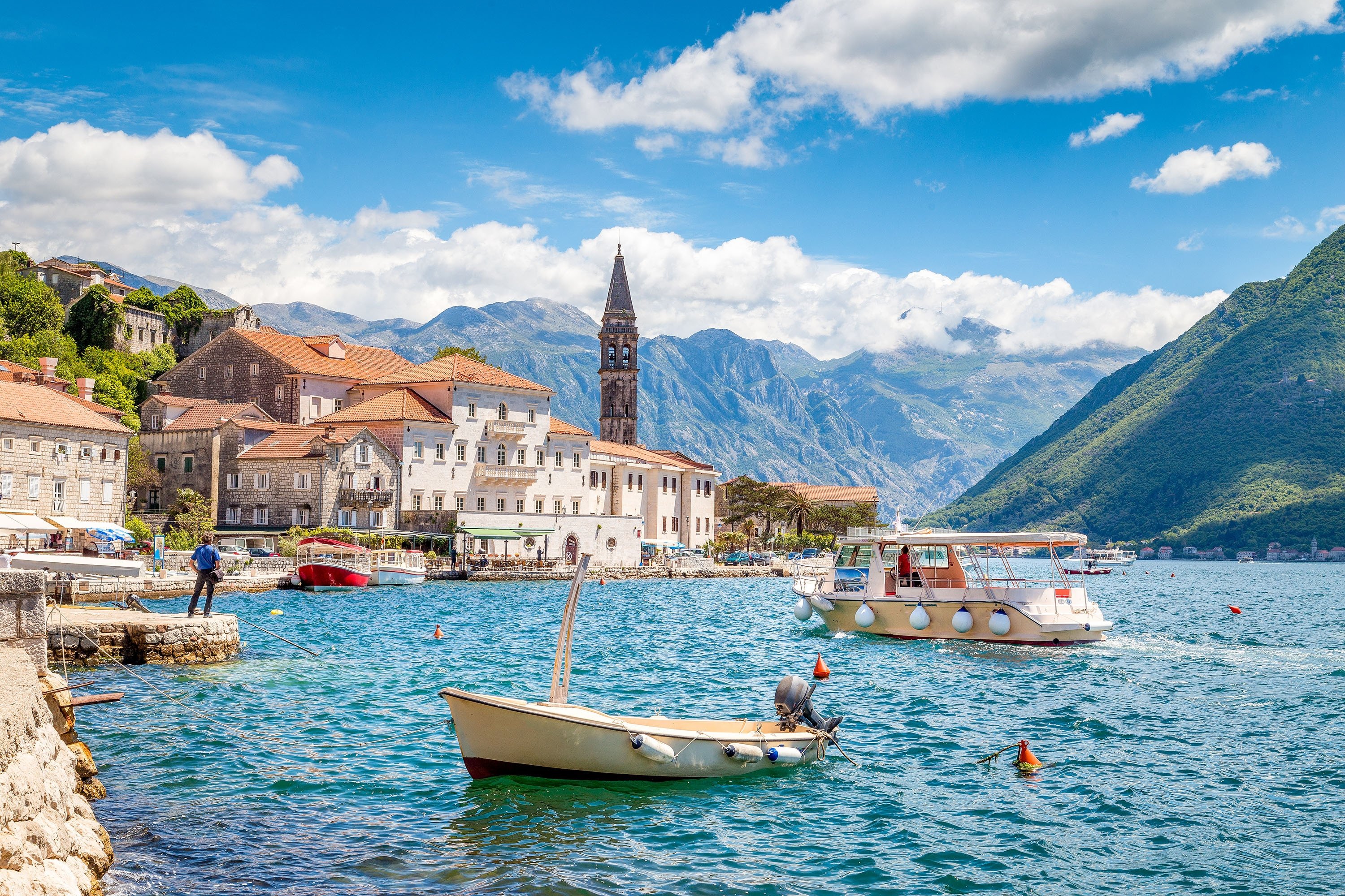 Small boats approach the scenic coast of the historic town of Perast, situated at the famous Bay of Kotor, Montenegro. (Shutterstock Photo)