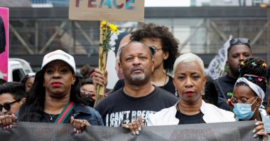 George Floyd's cousin Shareeduh Tate (front R) holds a banner while marching with others during the "One Year, What's Changed?" rally hosted by the George Floyd Global Memorial to commemorate the first anniversary of his death, outside the Hennepin County Government Center in Minneapolis, Minnesota, U.S., May 23, 2021. (Reuters Photo)