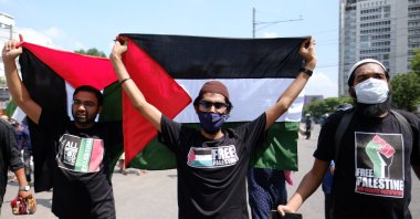 Bangladeshi men hold Palestinian flags as they participate in a protest against the Israeli attacks on Palestinians in Gaza, in Dhaka, Bangladesh, May 21, 2021. (AP Photo)
