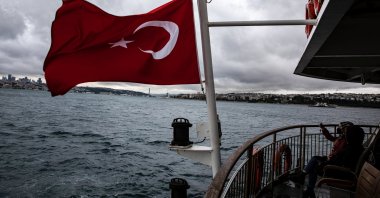 People traveling on a ferry from the Eminönü district to the Kadıköy district take pictures on a cloudy day, Istanbul, Turkey, May 21, 2021. (Photo by Getty Images)