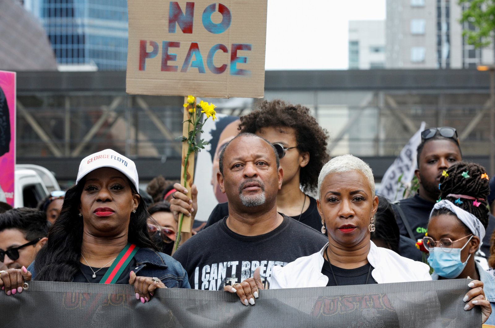 George Floyd's cousin Shareeduh Tate (front R) holds a banner while marching with others during the "One Year, What's Changed?" rally hosted by the George Floyd Global Memorial to commemorate the first anniversary of his death, outside the Hennepin County Government Center in Minneapolis, Minnesota, U.S., May 23, 2021. (Reuters Photo)