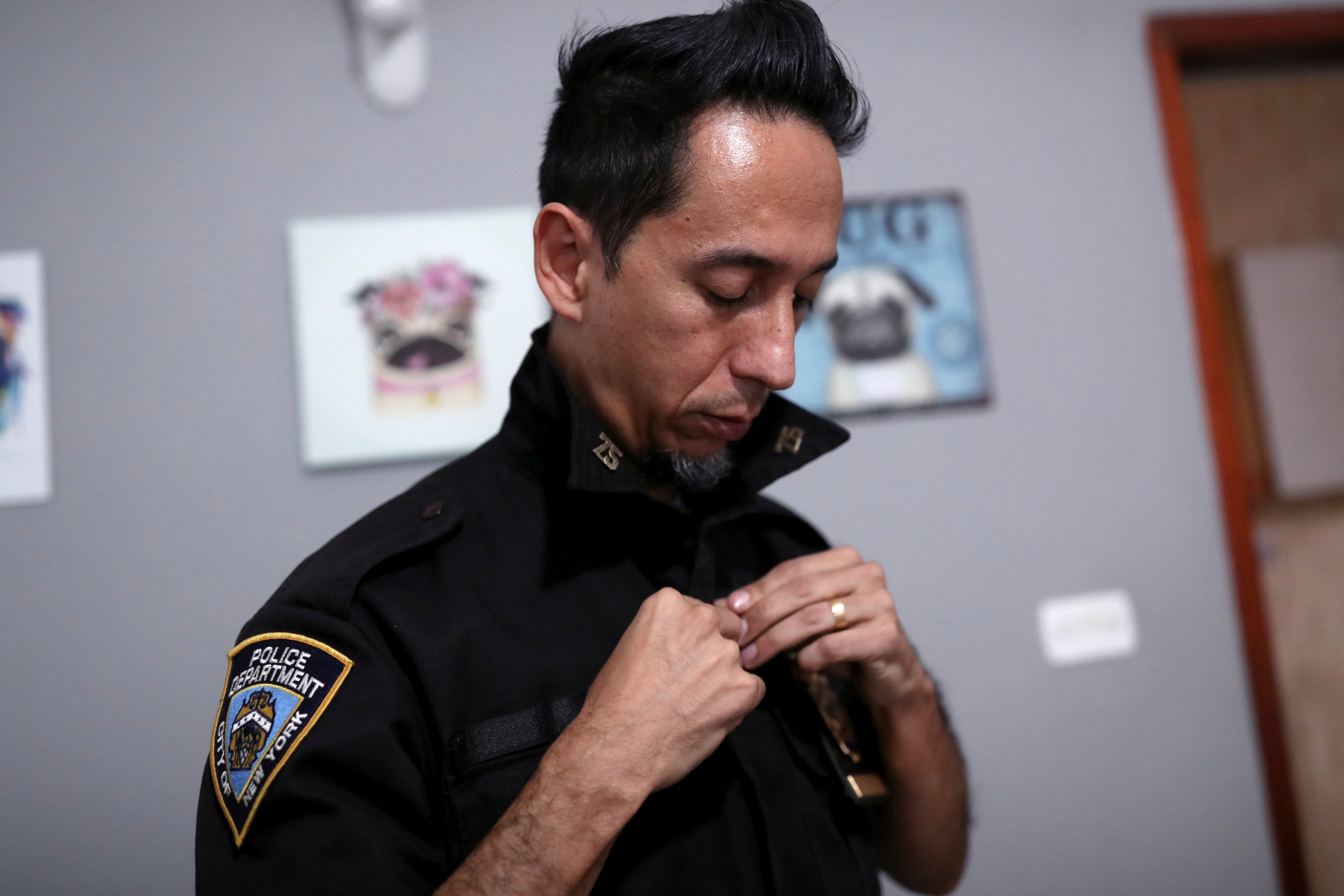 Eduardo Tai, a member of a group of Brazilian fans of the New York Police Department (NYPD) puts on his NYPD replica uniform in Sao Paulo, Brazil, May 22, 2021. (Reuters Photo)