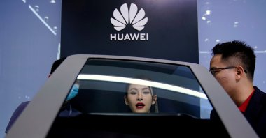People look at a display near a Huawei logo during a media day for the Auto Shanghai show, Shanghai, China, April 19, 2021. (Reuters Photo)