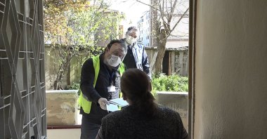 Social aid workers hand out cash aid to a woman in her home during the lockdown, in the capital, Ankara, Turkey, May 6, 2021.