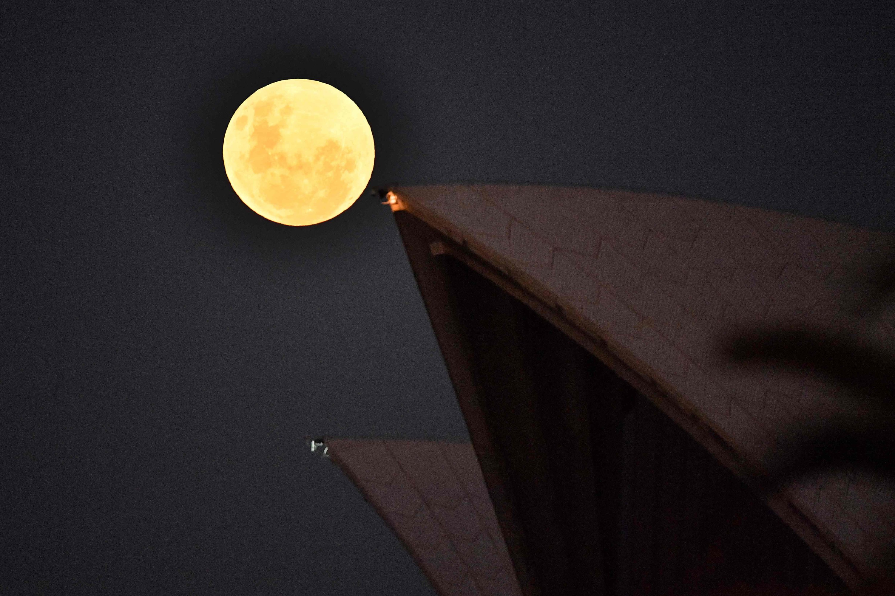 The Moon – ahead of a super blood moon total lunar eclipse that will be visible to stargazers across the Pacific – rises over the Opera House in Sydney, Australia, May 26, 2021. (AFP Photo)