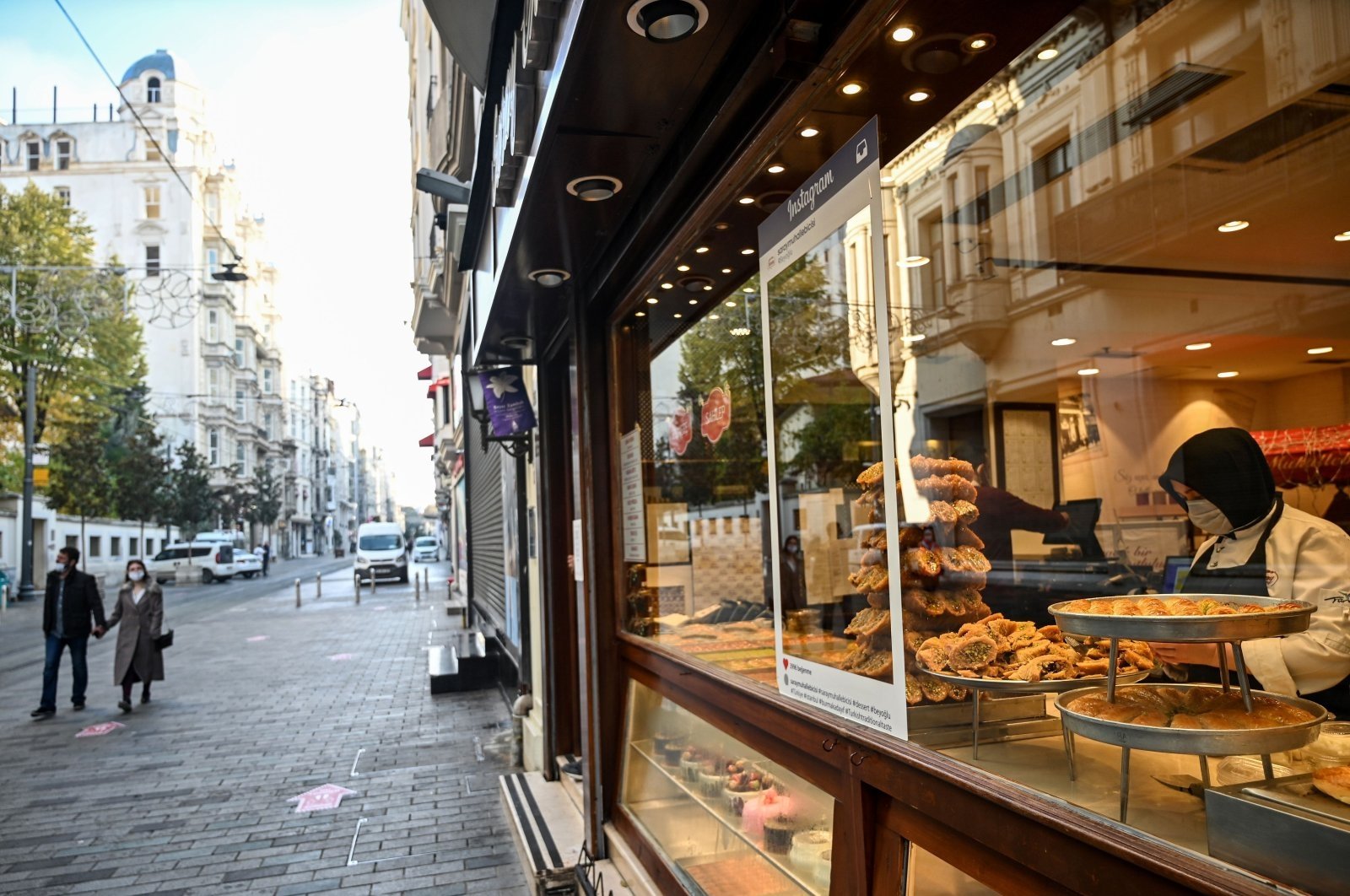 A woman in a cafe prepares food in a deserted Istiklal Avenue during a weekend curfew aimed at curbing the spread of the coronavirus pandemic, Istanbul, Turkey, Dec. 5, 2020. (AFP Photo)