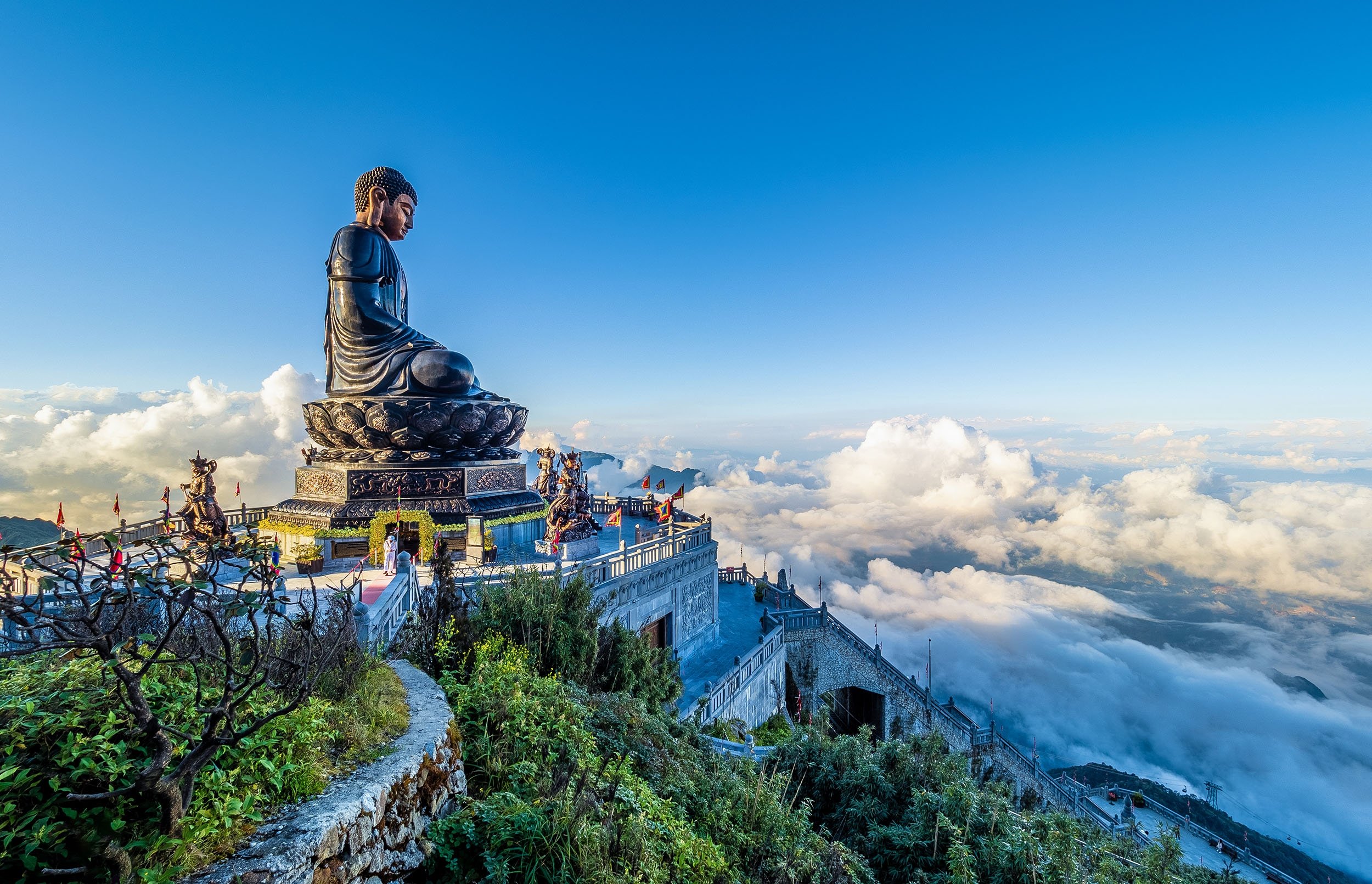 A giant Buddha statue sits on top of mount Fansipan in the town of Sa Pa with cloudy landscape in the background, Lao Cai, Vietnam. (Shutterstock Photo)