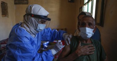 Ismail Öncel (R), 76, is administered a dose of the Chinese-made CoronaVac vaccine by nurse Meltem Gülcan at his house in the village of Gökçe, Mardin, Turkey, May 21, 2021. (AP Photo)