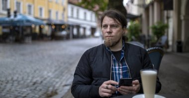 Viachka Krasulin, who fled Belarus after police arrested and beat him during demonstrations against authoritarian President Alexander Lukashenko in August 2020, sits at a cafe in Vilnius, Lithuania, May 19, 2021. (AP Photo)