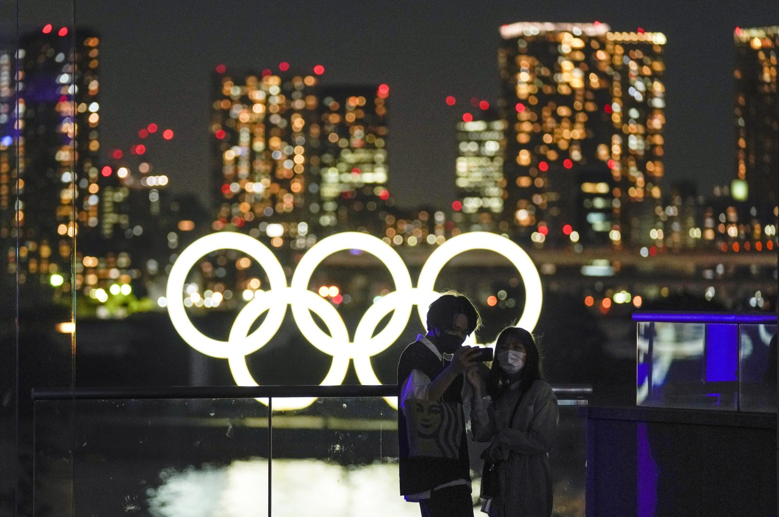 A couple poses for a selfie with an Olympic Rings monument set at Odaiba Marine Park, Tokyo, Japan, May 26, 2021. (EPA Photo)
