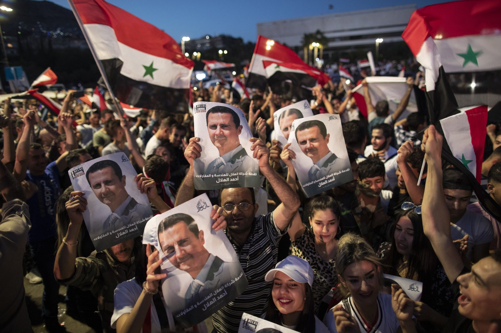 Syrian President Bashar Assad supporters hold up national flags and pictures of Assad as they celebrate at Omayyad Square, in Damascus, Syria, Thursday, May 27, 2021. (AP Photo)