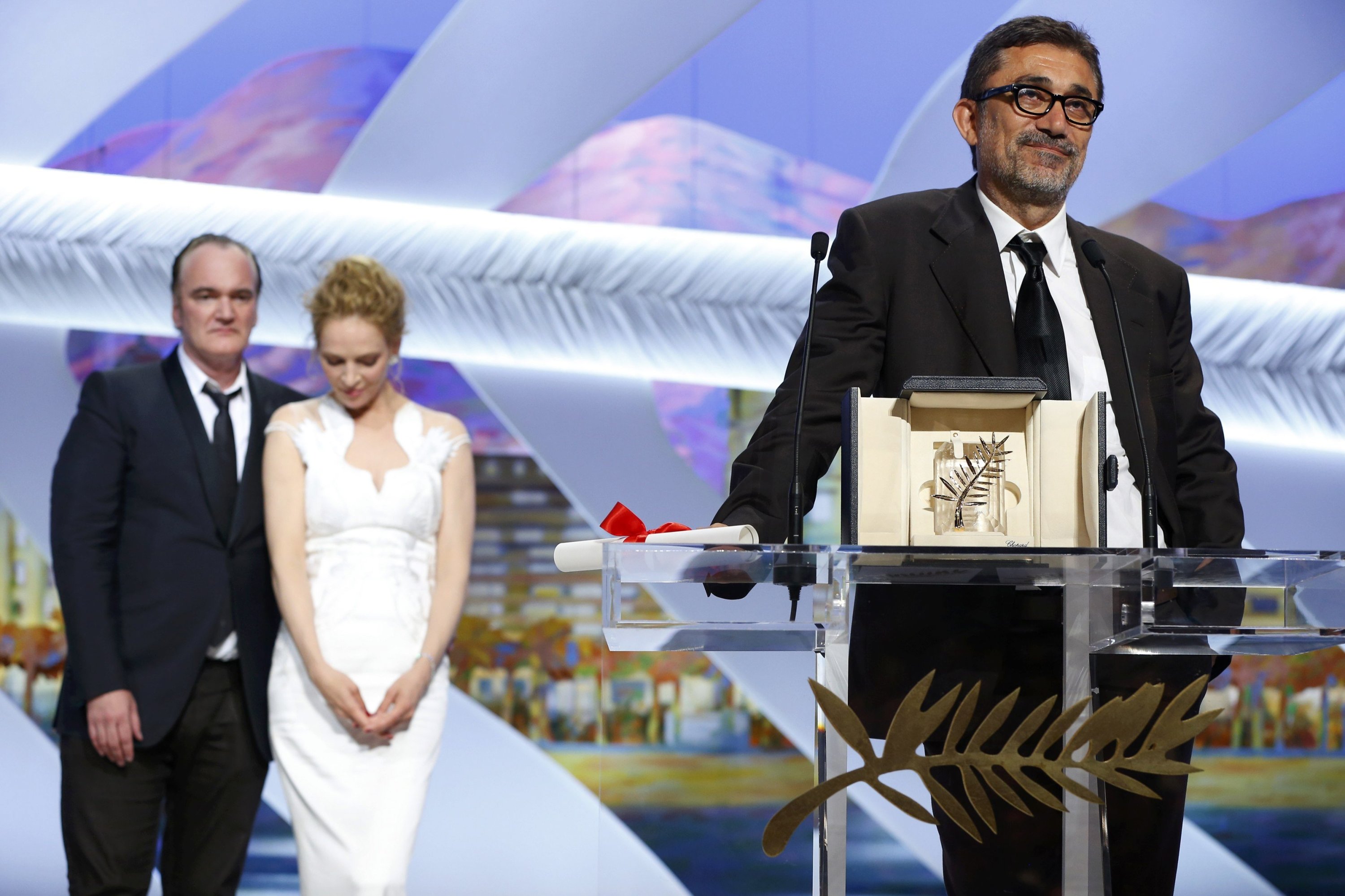 Director Quentin Tarantino (L) and actress Uma Thurman (2nd L) listen to director Nuri Bilge Ceylan, who won the palme d
