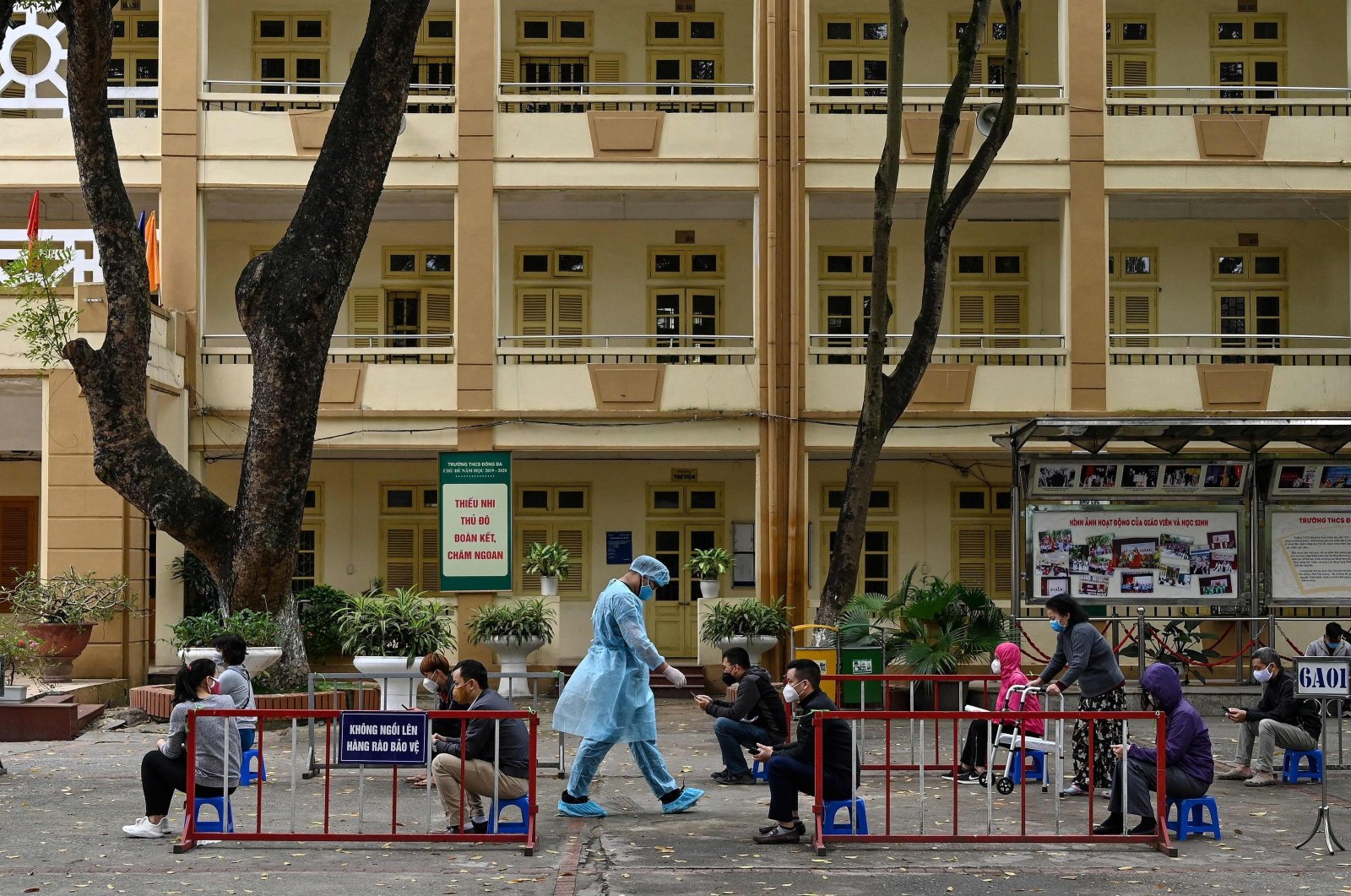 Residents, wearing face masks as a preventive measure against the spread of the COVID-19, practice social distancing as they wait to be tested at a makeshift rapid testing center near the Bach Mai hospital in Hanoi, Vietnam, March 31, 2020. (AFP Photo)