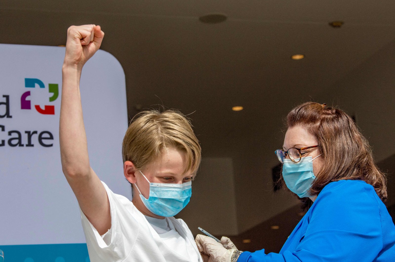 Charles Muro,13, celebrates being inoculated by Nurse Karen Pagliaro at Hartford Healthcare’s mass vaccination center at the Connecticut Convention Center in Hartford, Connecticut, U.S., on May 13, 2021. (AFP Photo)