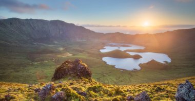 Sun shines over the horizon on the volcano crater with a lake on the island of Corvo, Azores, Portugal. (Shutterstock Photo)