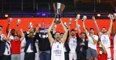 Anadolu Efes's Doğus Balbay celebrates with the trophy and teammates after winning the THY EuroLeague at Lanxess Arena, Cologne, Germany, May 30, 2021. (Reuters Photo)