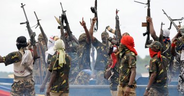 Fighters with the Movement for the Emancipation of the Niger Delta (MEND) raise their rifles to celebrate news of a successful operation by their colleagues against the Nigerian army in the Niger Delta, Sept. 17, 2008. (AFP Photo)