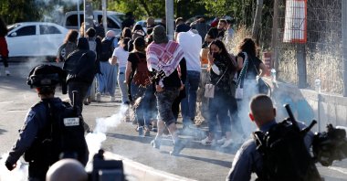 Israeli security forces fire tear gas as Palestinian protesters and activists flee, near an Israeli Police checkpoint at the entrance of the Sheikh Jarrah neighborhood in East Jerusalem, during a rally demanding the reopening of the roadblock, on May 29, 2021. (AFP Photo)