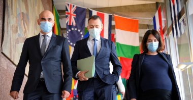 (L-R) Swiss Interior and Health Minister Alain Berset walks with the Swiss ambassador and permanent representative of Switzerland to the United Nations, Juerg Lauber, and Swiss Ambassador Nora Kronig Romero, the head of the International Affairs Division and vice director of the Federal Office of Public Health, before speaking at the opening of the 74th World Health Assembly at the World Health Organization headquarters, in Geneva, Switzerland, May 24, 2021. (Laurent Gillieron/Pool via Reuters)