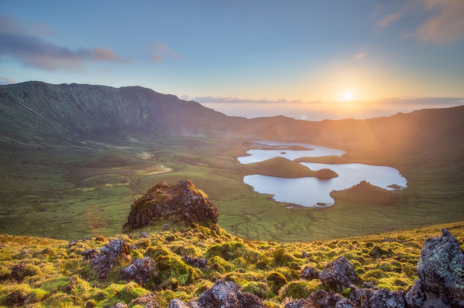 Sun shines over the horizon on the volcano crater with a lake on the island of Corvo, Azores, Portugal. (Shutterstock Photo)