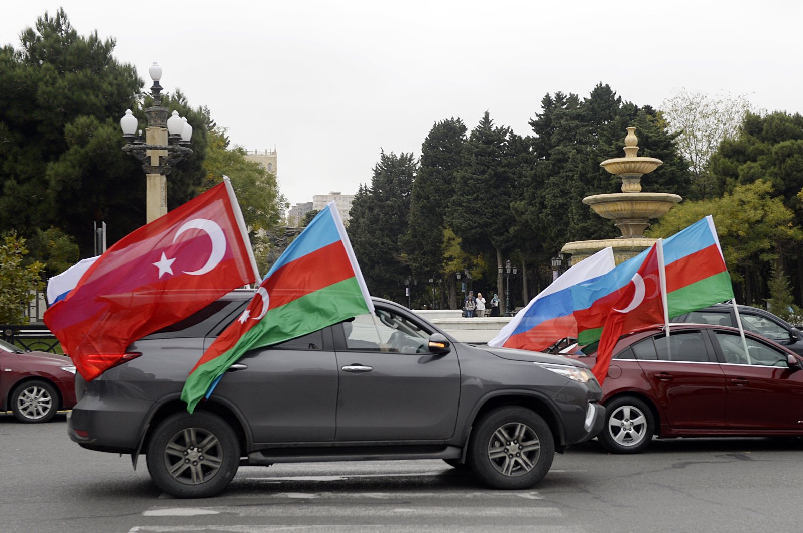 Motorists hold Azerbaijani, Turkish and Russian flags during celebrations of the country's victory over Armenia after a weekslong war over the disputed Nagorno-Karabakh region, Baku, Azerbaijan, Nov. 20, 2020. (AFP Photo)