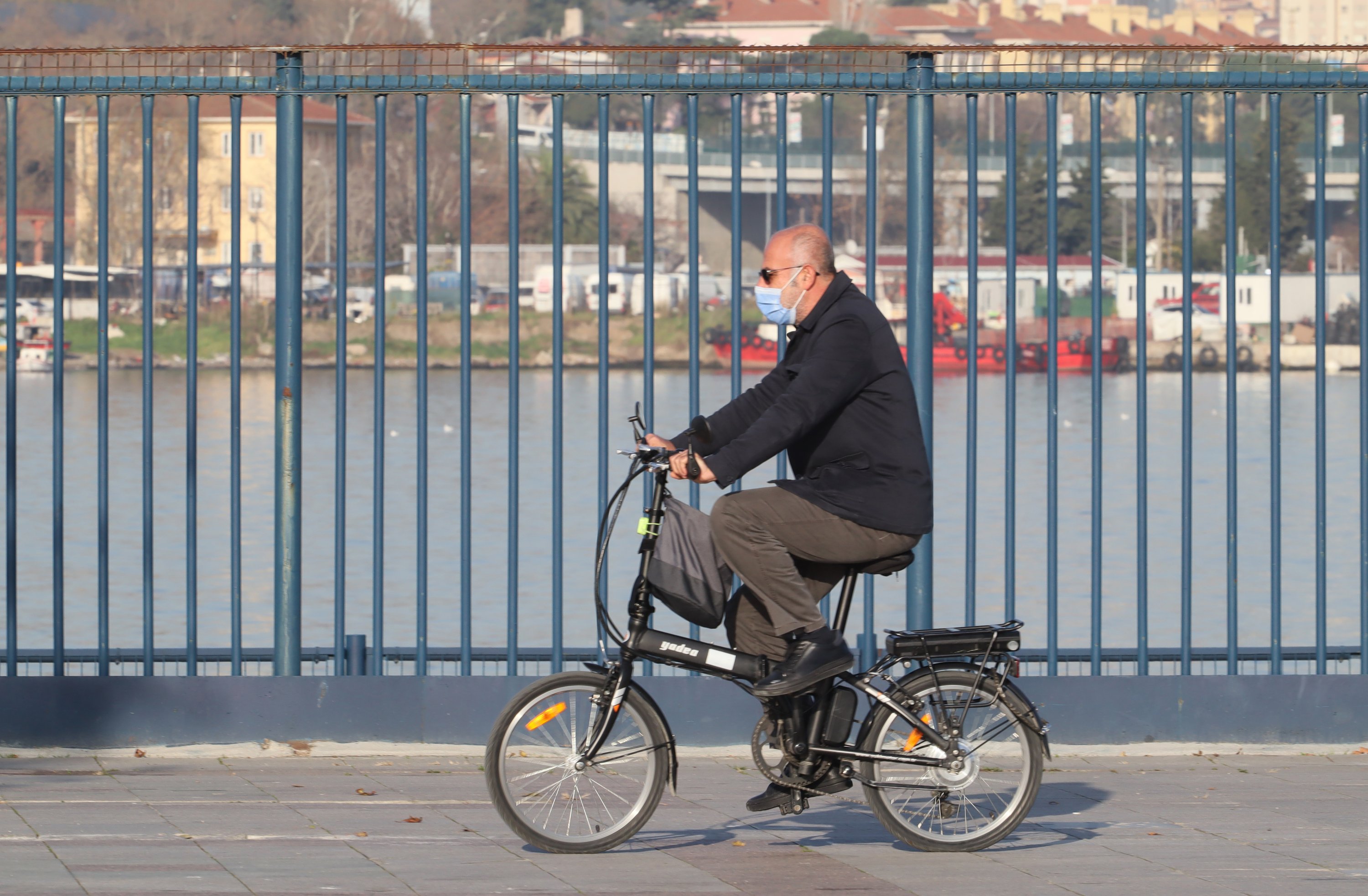A man with a mask rides a bicycle on a sunny day in January in Kadikoy, Istanbul, Turkey, Jan. 2, 2021. (Shutterstock Photo)