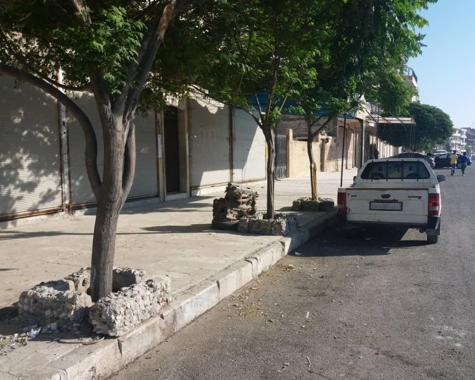 A pickup sits in front of shops that were closed to protest YPG oppression in Manbij, Syria, May 31, 2021. (AA Photo)