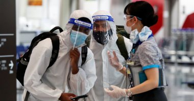 Passengers wearing personal protection equipment (PPE) are escorted by an airline employee at Narita international airport, amid the coronavirus pandemic, Narita, Tokyo, Japan, June 1, 2021.  (Reuters Photo)