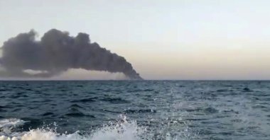 This image made from a video released on Wednesday, June 2, 2021 by Asriran.com, shows smoke rising from Iran's navy support ship Kharg in the Gulf of Oman. (AP Photo)