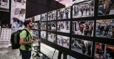 A visitor examines photos at the "Witness to the 2021 Crime" exhibition in the Gaza Strip, Palestine, June 1, 2021. (AA Photo)