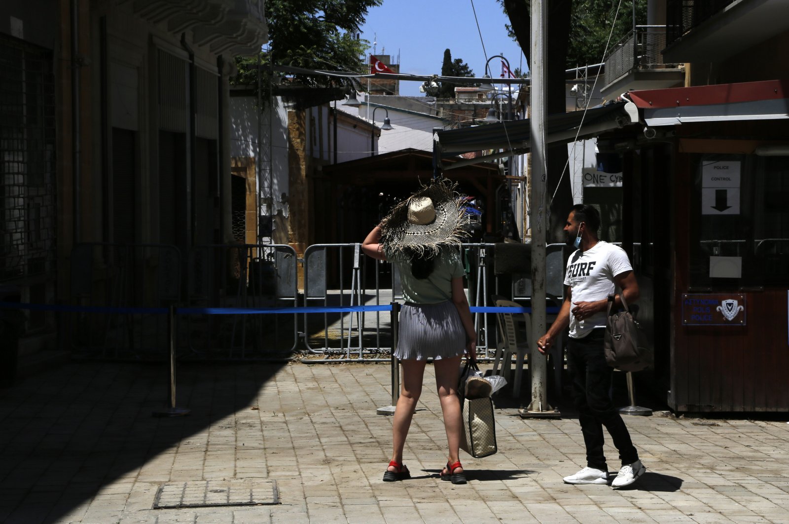 Tourists stand in front of police barriers at a closed crossing point between the Greek Cypriots (south) and the Turkish Cypriots (north), on the Ledras pedestrian street in the divided capital Nicosia, on the island of Cyprus, June 2, 2021. (AP Photo)