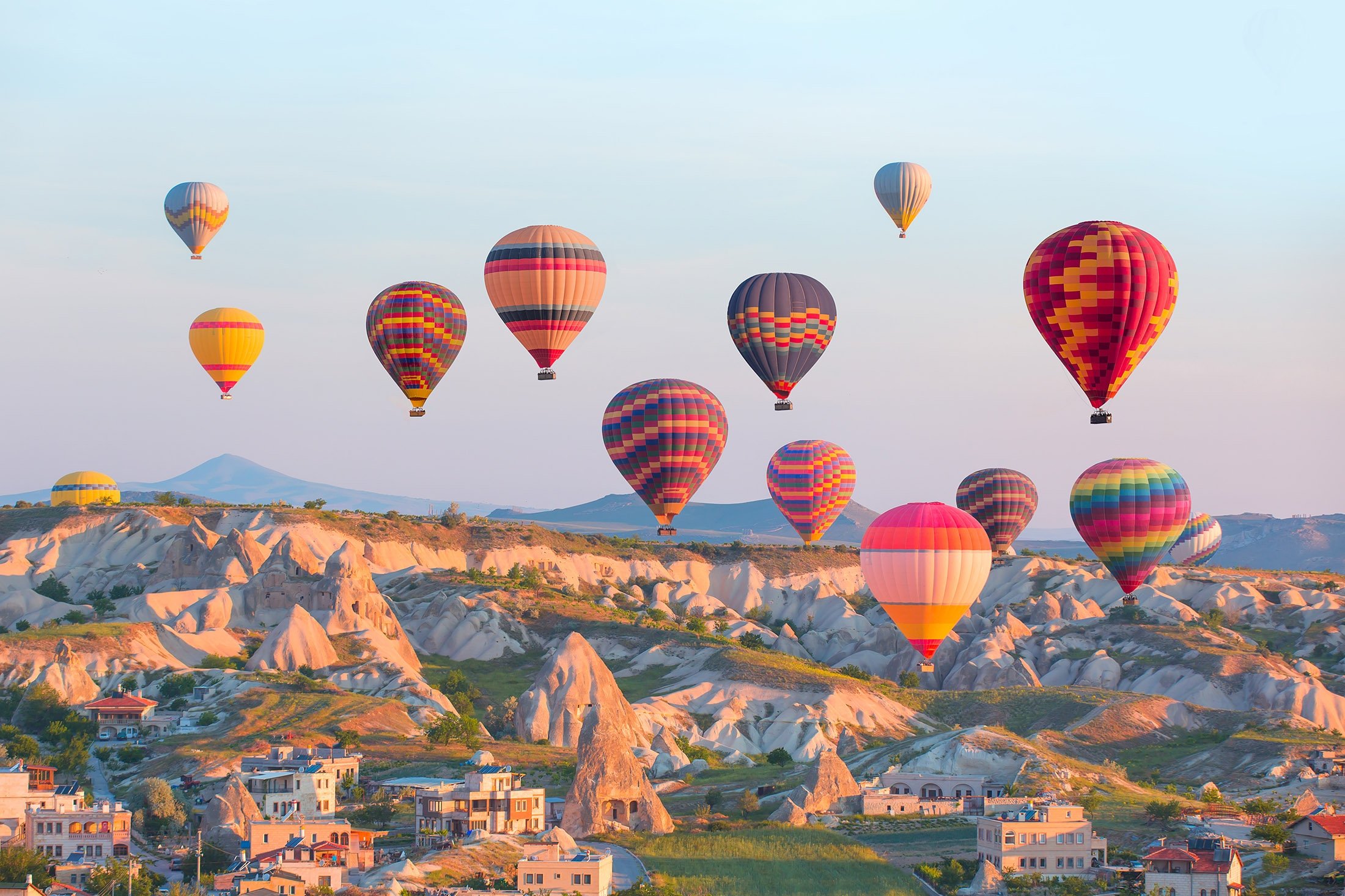 Hot air balloons flying over rock landscape at Cappadocia, central Turkey. (Shutterstock Photo)