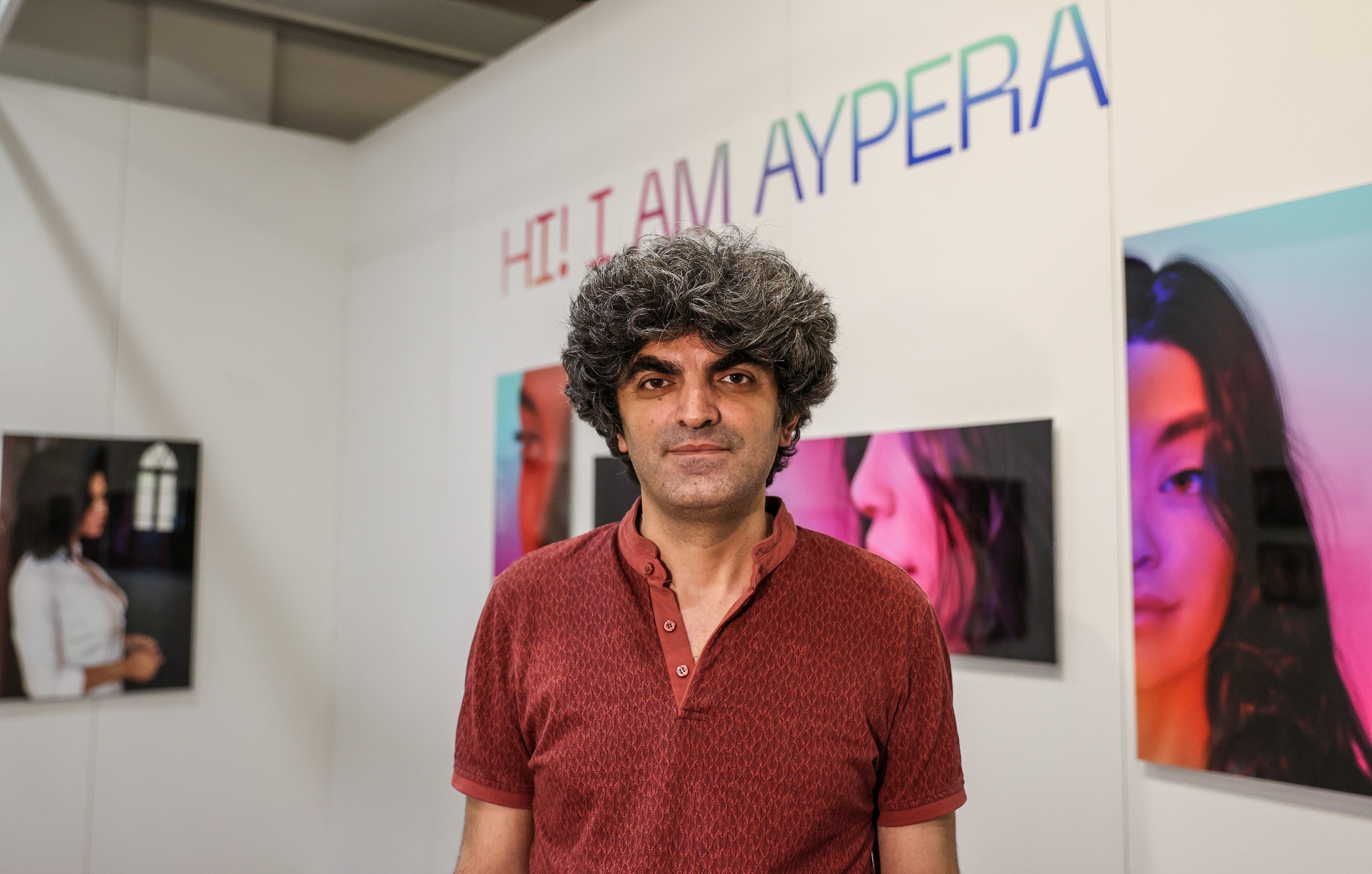 Designer and instructor Bager Akbay poses in front of the Aypera poster exhibition at Contemporary Istanbul, Istanbul, Turkey, June 2, 2021. (AA Photo)