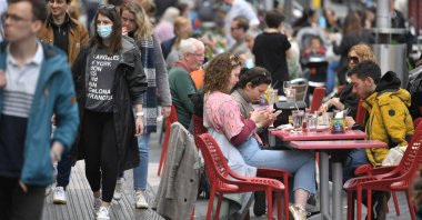 Members of the public enjoy refreshments at tables set up outside a cafe in south Kensington, London, U.K., May 18, 2021. (AFP Photo)