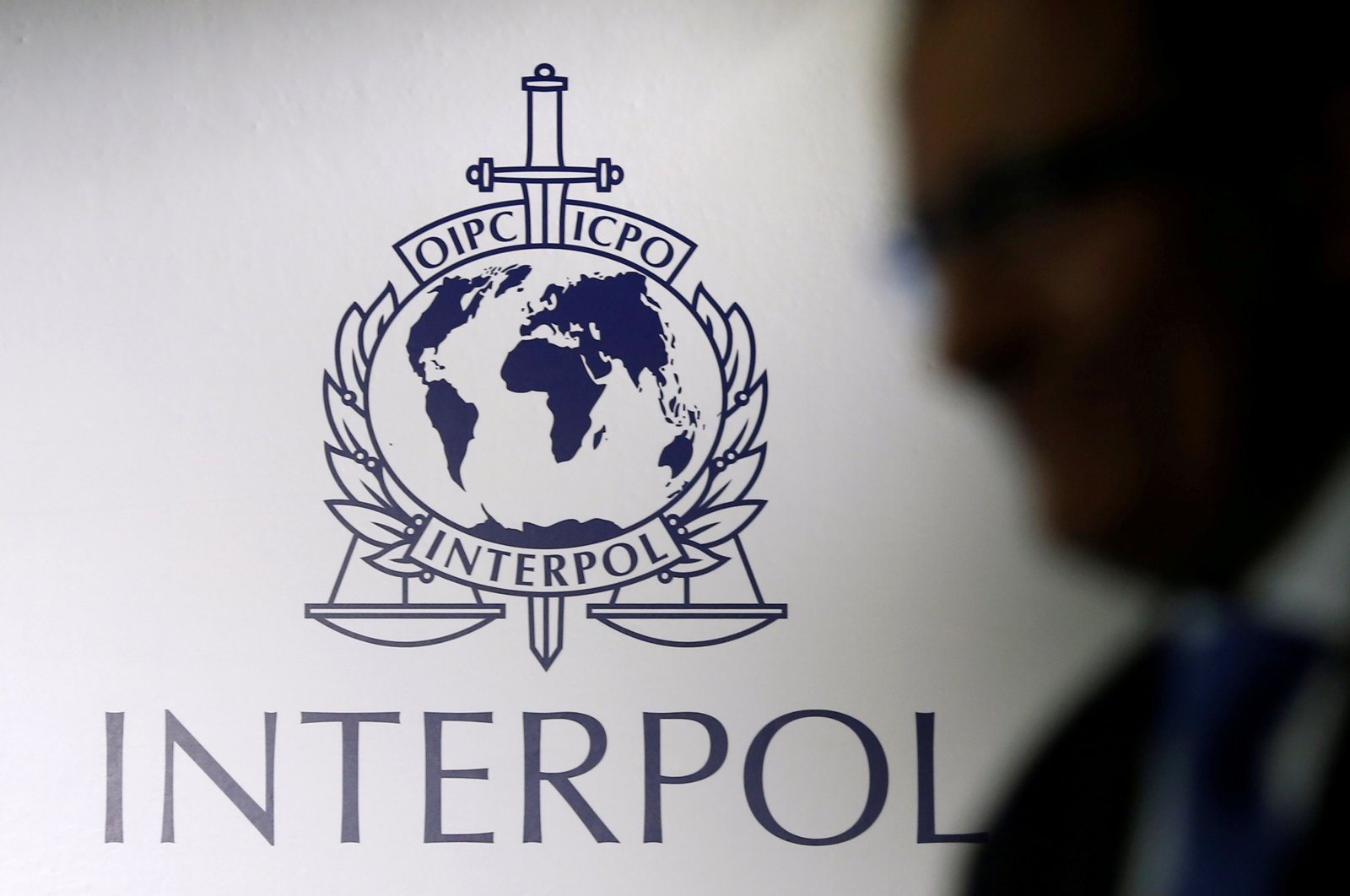 A man passes an Interpol logo during the handing over ceremony of the new premises for Interpol's Global Complex for Innovation, a research and development facility, in Singapore, September 30, 2014. (REUTERS Photo)