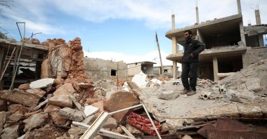 A man stands amid the rubble of a destroyed building in the town of Saraqib, in the northwestern province of Idlib, Syria, Jan. 31, 2020. (AFP Photo)