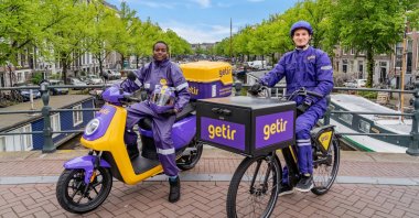 Getir couriers pose in front of a canal in Amsterdam, The Netherlands, May 28, 2021. (Courtesy of Getir)