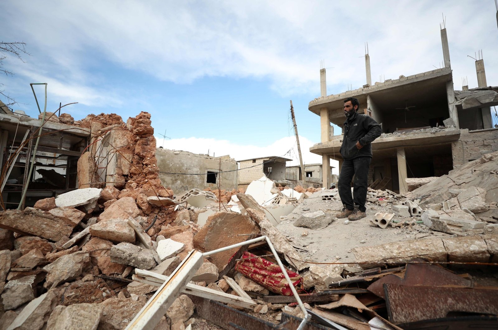 A man stands amid the rubble of a destroyed building in the town of Saraqib, in the northwestern province of Idlib, Syria, Jan. 31, 2020. (AFP Photo)