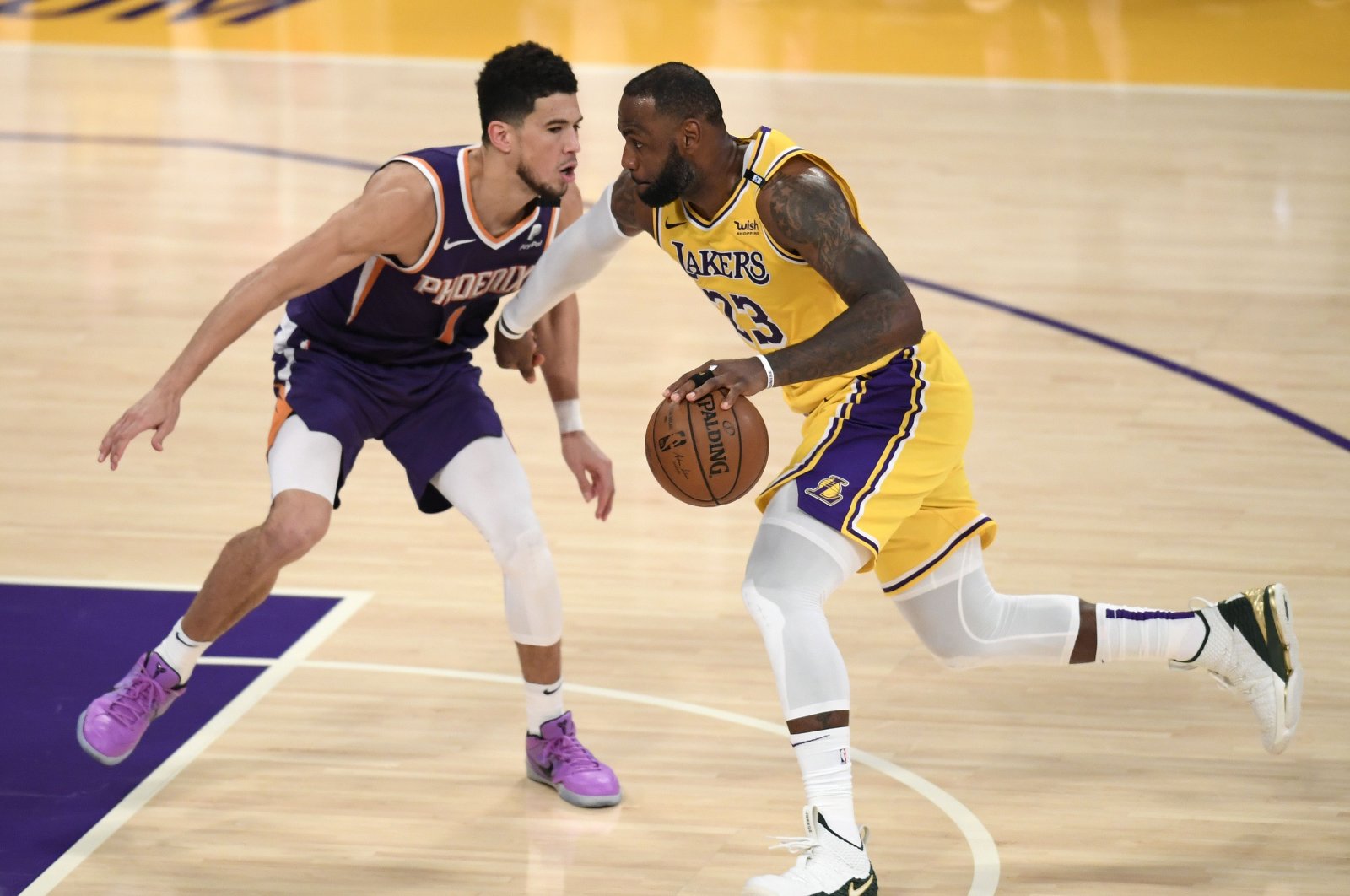 Los Angeles Lakers' LeBron James (R) drives on Phoenix Suns' Devin Booker during an NBA Western Conference playoff match at Staples Center, in Los Angeles, U.S., June 3, 2021. (AFP Photo)
