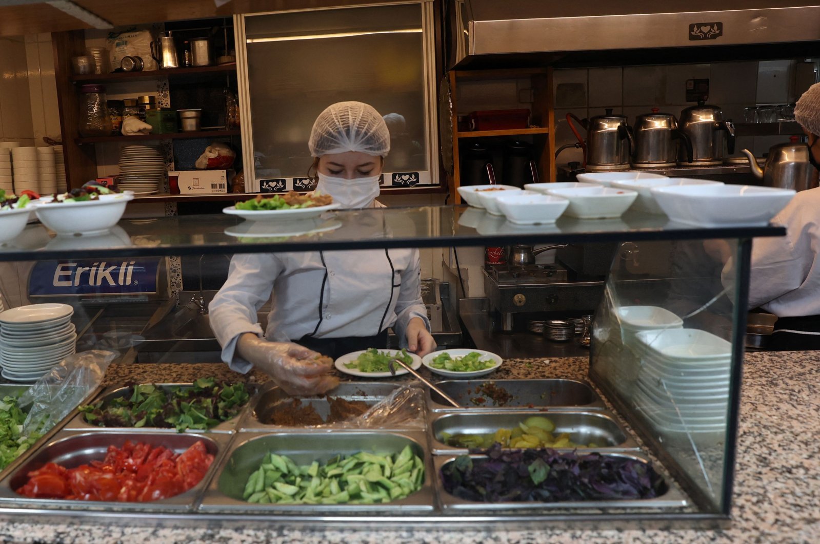Chefs wearing masks prepare meals for customers at a restaurant in the capital Ankara, Turkey, June 2, 2021. (AFP PHOTO)