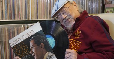 Ray Cordeiro, Hong Kong's oldest DJ shows a vinyl record at his home in Hong Kong, May 27, 2021. (AP Photo)