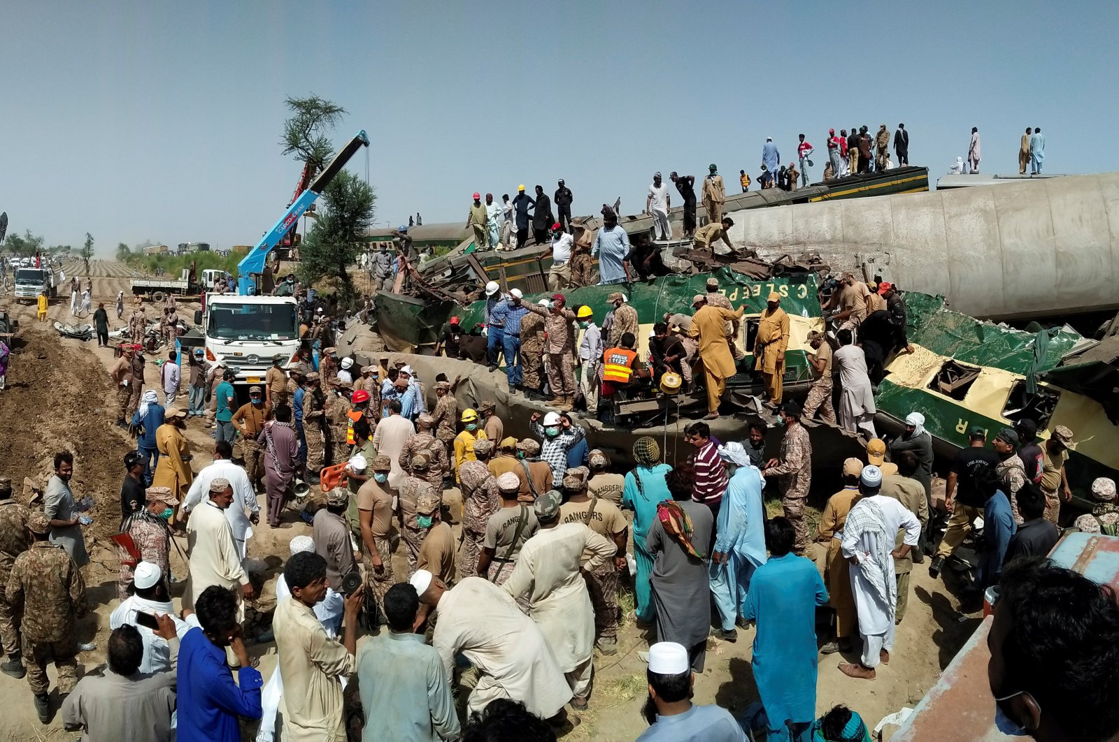 Paramilitary soldiers and rescue workers gather at the site following a collision between two trains in Ghotki, Pakistan June 7, 2021. (Reuters Photo)