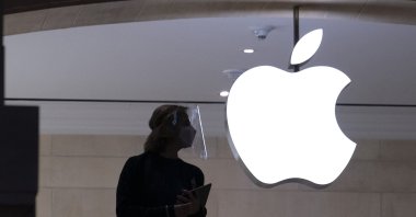An Apple store employee wears personal protective equipment in New York, Feb. 5, 2021. (AP Photo)