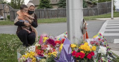 Nafisa Azima and her daughter Seena Safdari attend a memorial at the location where a family of five was hit by a driver, in London, Ontario, Monday, June 7, 2021. (AP Photo)