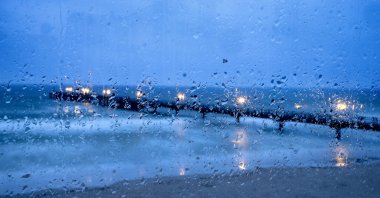 The pier of the Baltic Sea in Scharbeutz, northern Germany, is seen behind raindrops, Scharbeutz, Germany, April 11, 2021. (AP Photo)