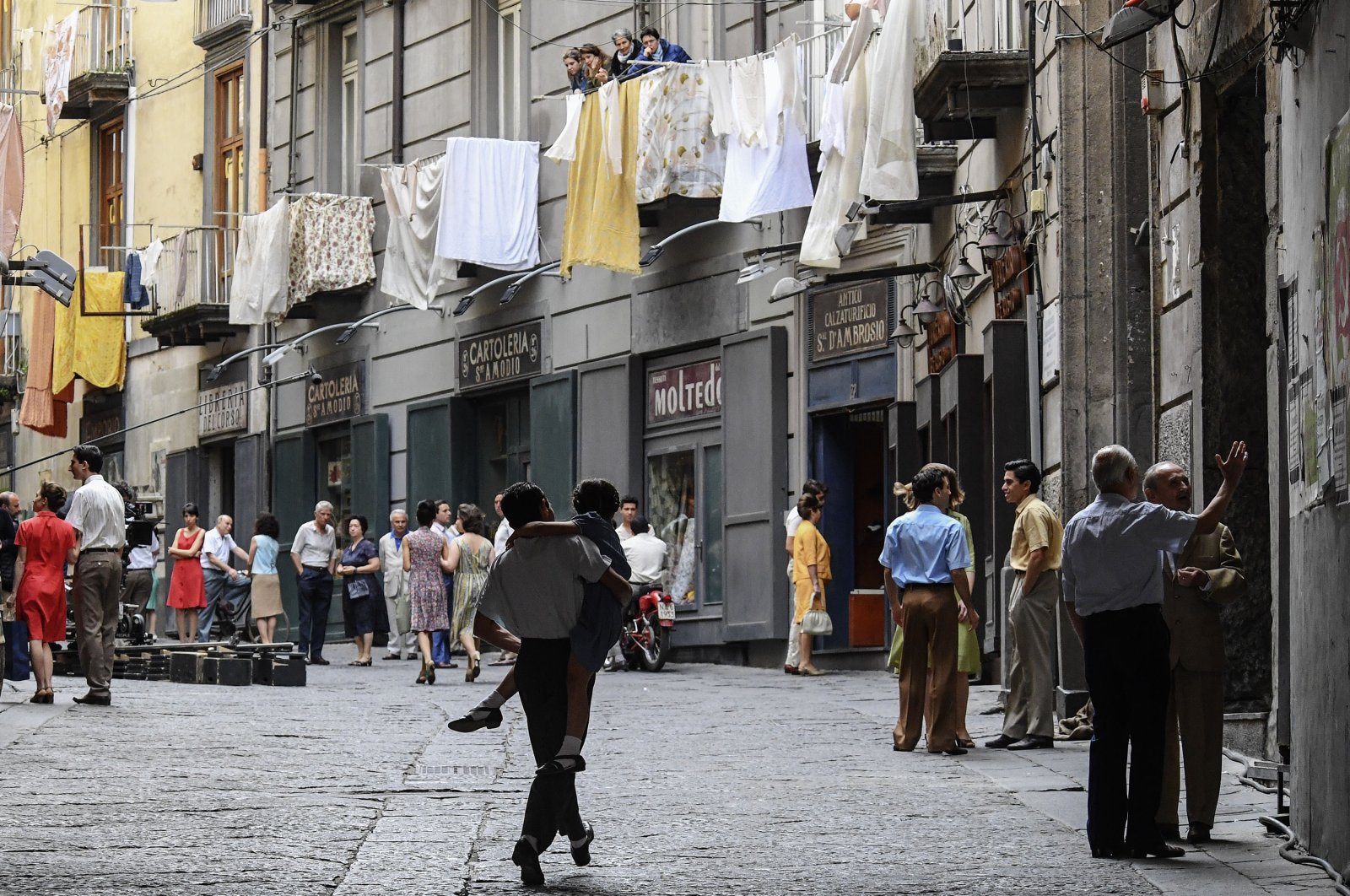 Extras walk along a crowded street on the set of the TV series "My Brilliant Friend" ("L'amica geniale") based on the novels of Elena Ferrante, in Naples, Italy, Jan. 13, 2021. (Getty Images)