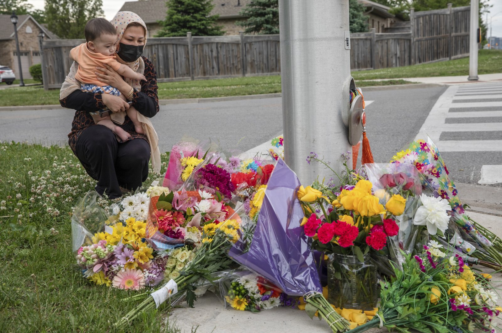 Nafisa Azima and her daughter Seena Safdari attend a memorial at the location where a family of five was hit by a driver, in London, Ontario, Monday, June 7, 2021. (AP Photo)